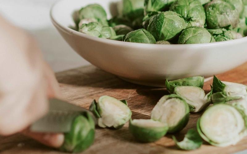 a person cutting brussel sprouts